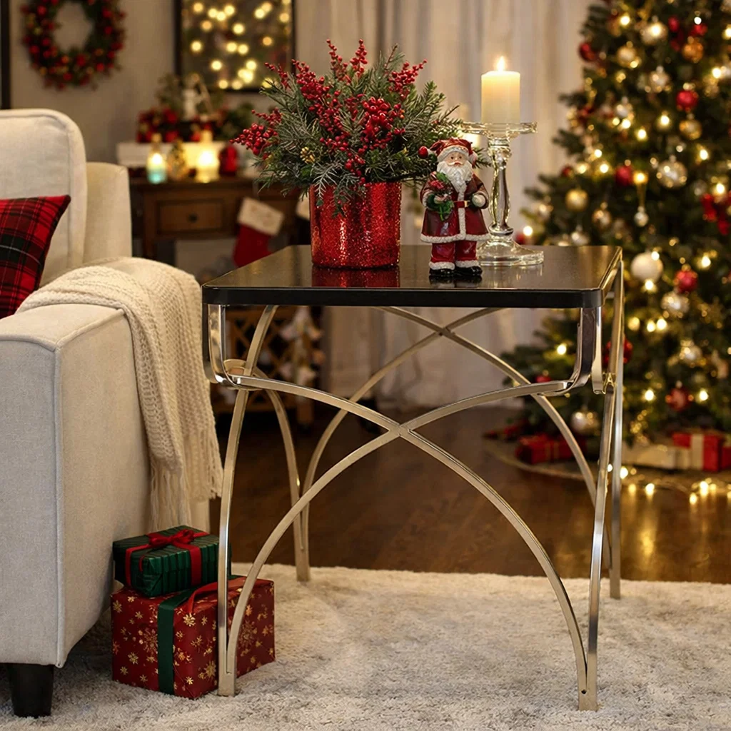 Elegant metal accent side table styled with festive Christmas décor, candle holder, floral arrangement, and holiday accents in a cozy living room.